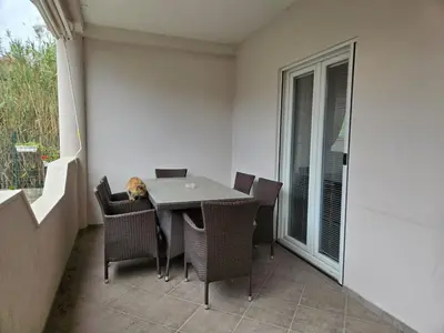 a cat sleeping on a table on a balcony at Apartment Anna in Polje