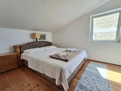 a bedroom with a bed and a window at Sveti Stefan Family Apartments in Budva