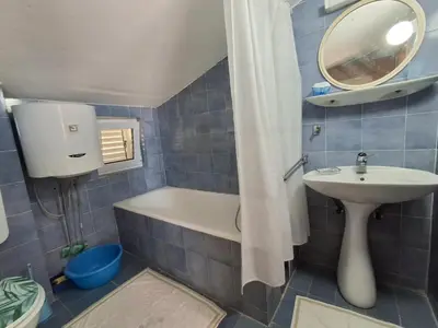 a bathroom with a tub and a sink and a mirror at Sveti Stefan Family Apartments in Budva