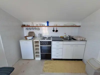 a small kitchen with a stove and a sink at Sveti Stefan Family Apartments in Budva