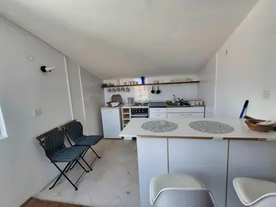 a small kitchen with a counter and chairs in it at Sveti Stefan Family Apartments in Budva