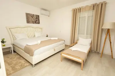 a bedroom with a large white bed and a window at LuxuryHomeUlcinj2 in Ulcinj