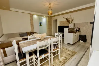 a dining room and living room with a table and chairs at LuxuryHomeUlcinj2 in Ulcinj