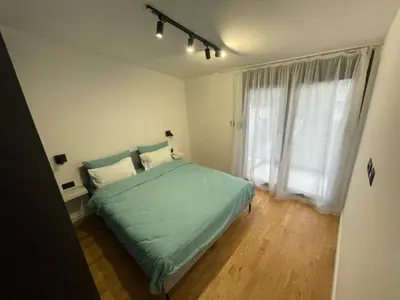a bedroom with a green bed and a window at Apartment Tara in Podgorica