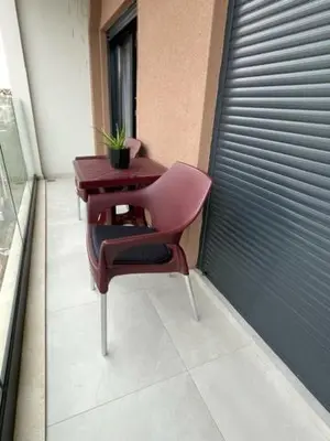 a pink chair and a table on a balcony at Apartment Tara in Podgorica