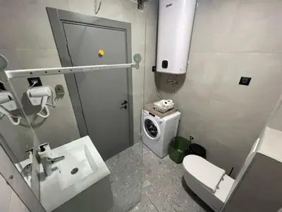 a bathroom with a sink and a washing machine at Apartment Tara in Podgorica