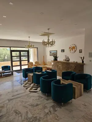 a lobby with blue chairs and a waiting room at Villa Ponta in Buljarica