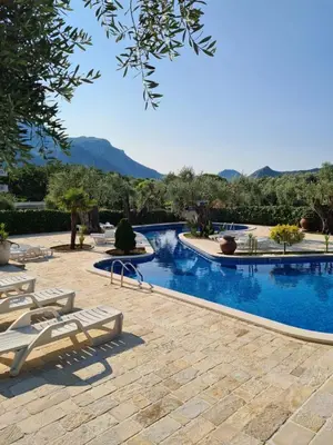 a swimming pool with chaise lounge chairs in a resort at Villa Ponta in Buljarica