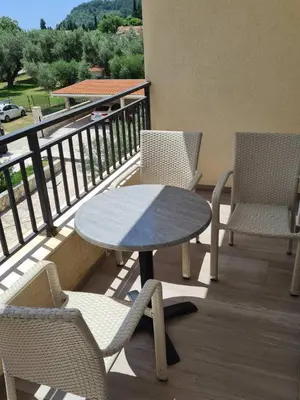 a patio with a table and chairs on a balcony at Villa Ponta in Buljarica