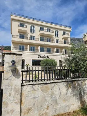 a large building with a fence in front of it at Villa Ponta in Buljarica