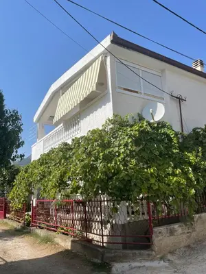 a white house with a tree in front of it at Guest house in Sutomore