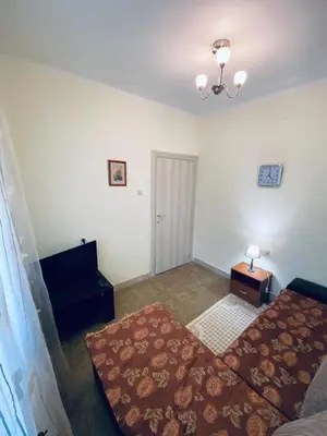 a living room with a bed and a table at Guest house in Sutomore