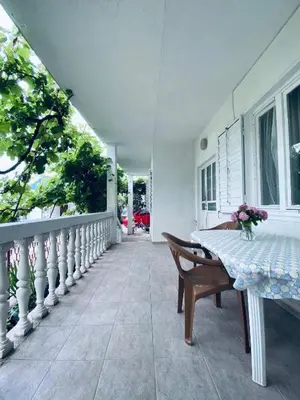 a porch of a house with a table and chairs at Guest house in Sutomore