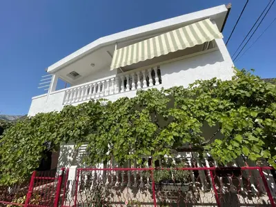 a white house with a fence in front of it at Guest house in Sutomore