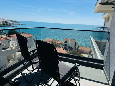 two chairs on a balcony with a view of the ocean at Mellas Premium Apartment in Dobra Voda