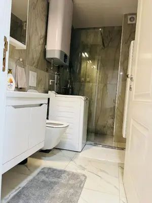a white bathroom with a toilet and a shower at Mellas Premium Apartment in Dobra Voda