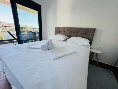 a bedroom with a white bed with towels on it at Mellas Premium Apartment in Dobra Voda