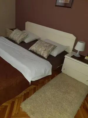 a bedroom with a bed and a table with a lamp at Apartments Ant in Budva