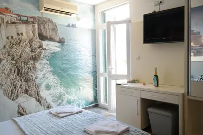 a bedroom with a painting of the ocean on the wall at Kuca Radovic in Petrovac na Moru