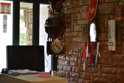 a room with a brick wall with a computer on a desk at Kuca Radovic in Petrovac na Moru