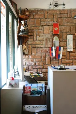 a desk with a computer and a brick wall at Kuca Radovic in Petrovac na Moru