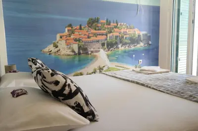 a bedroom with a wall mural of a resort at Kuca Radovic in Petrovac na Moru