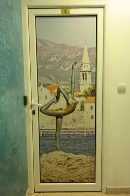 a door with a picture of a woman doing a kick at Kuca Radovic in Petrovac na Moru