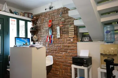 a room with a brick wall and a desk at Kuca Radovic in Petrovac na Moru