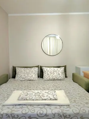 a bedroom with a bed with a round mirror at Felicia Apartments in Budva