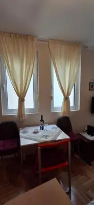 a living room with a table and two windows at Felicia Apartments in Budva