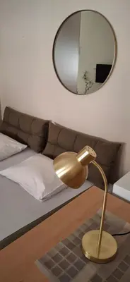 a gold lamp in front of a bed with a mirror at Felicia Apartments in Budva