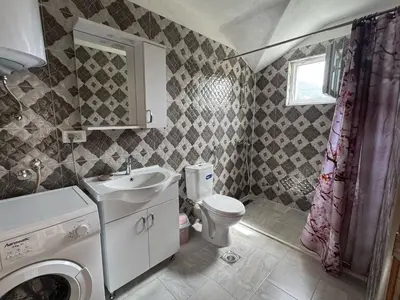 a bathroom with a sink and a washing machine at Valentina Apartman in Radanovići