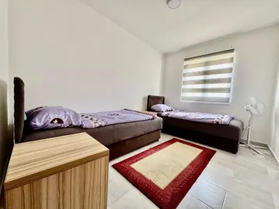 a bedroom with two beds and a window at Valentina Apartman in Radanovići