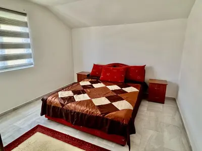 a bedroom with a bed with red pillows at Valentina Apartman in Radanovići