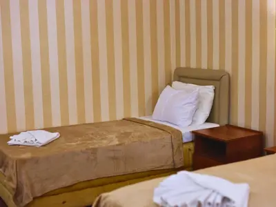 a hotel room with two beds with white pillows at Central Hotel & Restaurant in Budva