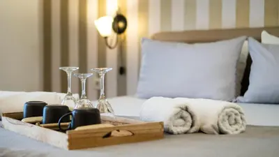 a tray of towels and wine glasses on a bed at Central Hotel & Restaurant in Budva