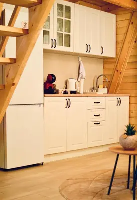 a kitchen with white cabinets and wooden ceilings at Wooden House Šapat sela in Podgorica
