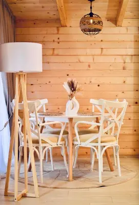 a dining room with a white table and chairs at Wooden House Šapat sela in Podgorica