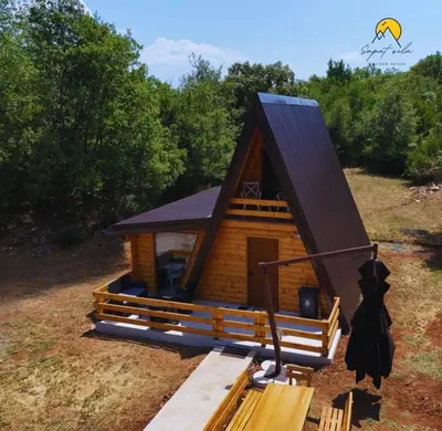 a small log cabin with a pitched roof at Wooden House Šapat sela in Podgorica