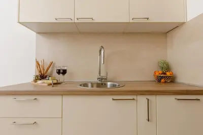 a kitchen counter with a sink and a glass of wine at Apartment Noel Kotor Dobrota in Kotor