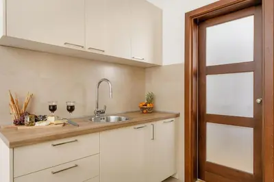 a kitchen with white cabinets and a sink at Apartment Noel Kotor Dobrota in Kotor