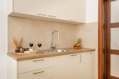 a kitchen with a sink and two glasses of wine at Apartment Noel Kotor Dobrota in Kotor