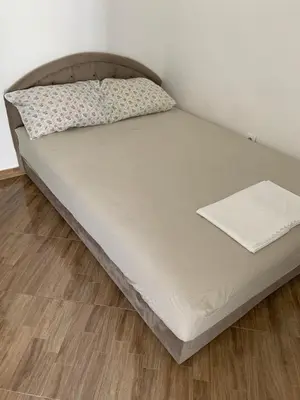 a bed in a room with a wooden floor at Apartmani Duretic in Sutomore