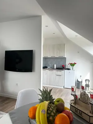a kitchen with a table with fruits on it at Airport Apartments MM in Golubovci