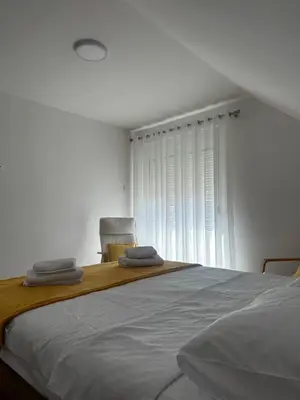 a bedroom with a bed with two towels on it at Airport Apartments MM in Golubovci