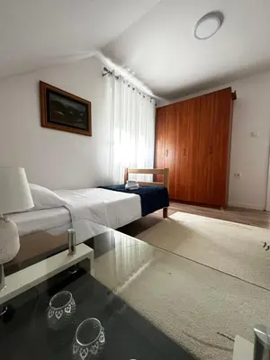 a bedroom with a bed and a glass table at Airport Apartments MM in Golubovci
