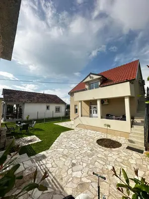 a house with a red roof and a patio at Airport Apartments MM in Golubovci