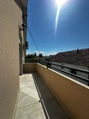 a balcony of a building with the sun in the sky at Airport Apartments MM in Golubovci