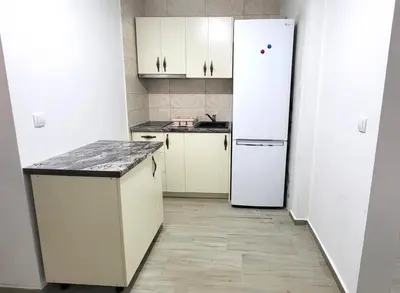 a kitchen with white cabinets and a refrigerator at Apartman Zinzula in Petrovac na Moru