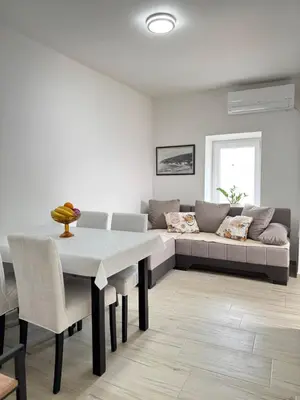 a living room with a table and a couch at Apartman Zinzula in Petrovac na Moru